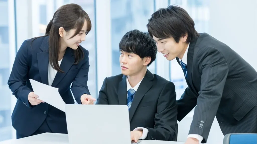 スーツを着た男女が笑顔で話をしている