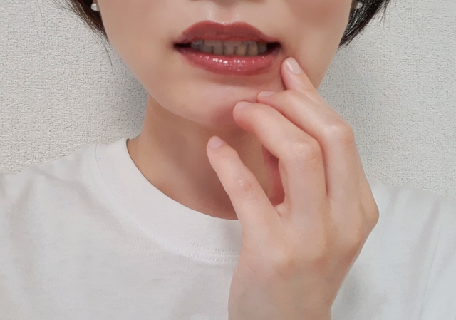 口元に手を当てる女性
