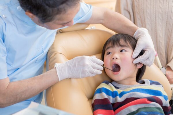 歯科医師が子どもの口の中を診察している様子