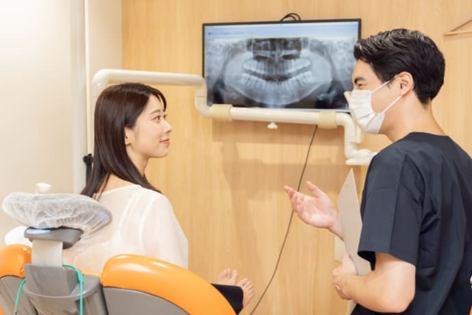 歯科 レントゲン説明 患者に治療内容を説明する歯科医師