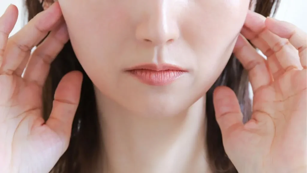 顎を抑えている女性