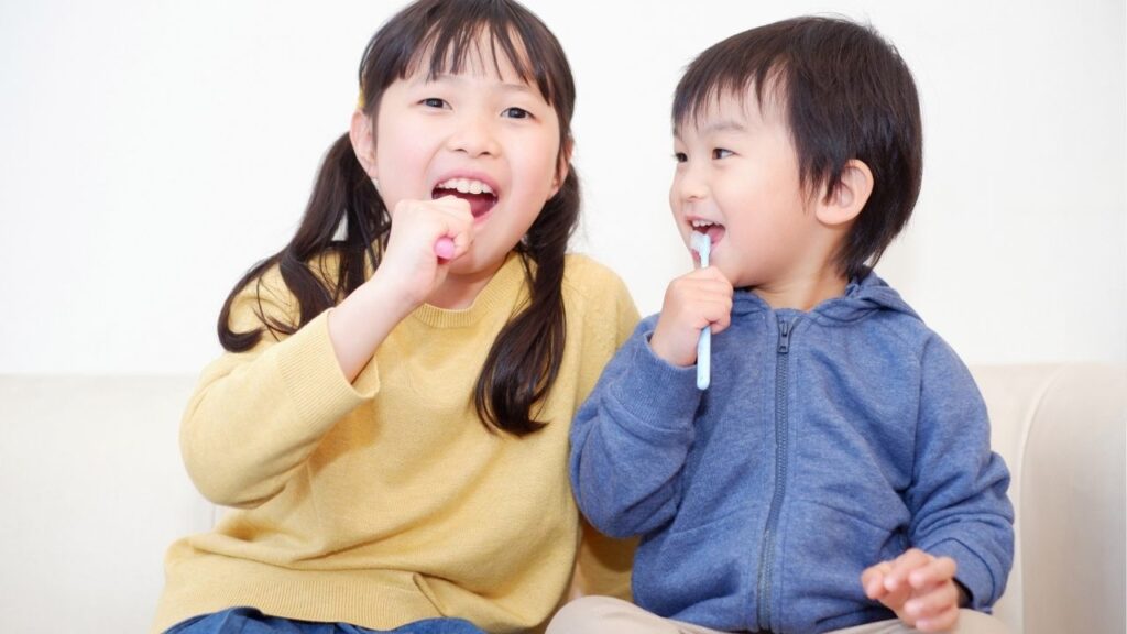 笑顔で歯を磨いている女の子と男の子