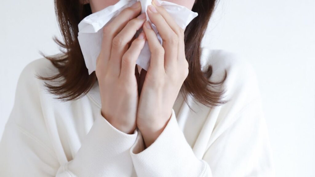 ティッシュで鼻を抑える女性