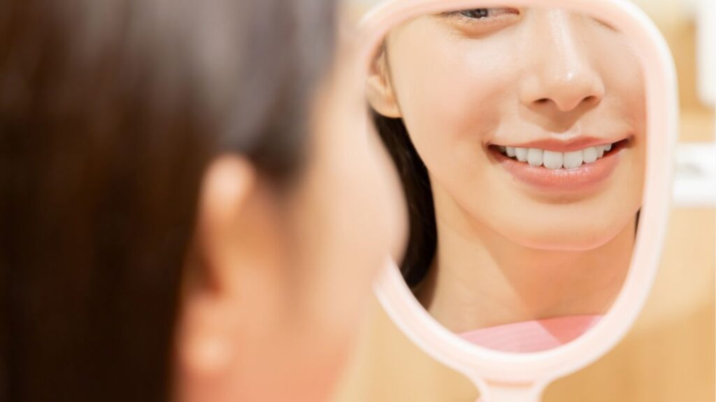 手鏡をもって微笑む女性