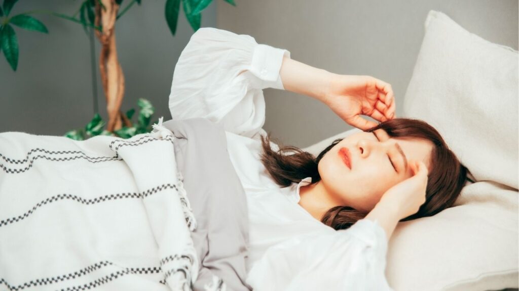 ベットで寝苦しそうにしている女性