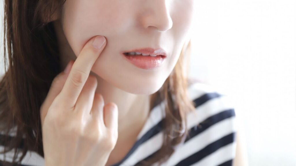 口元を指で抑える女性