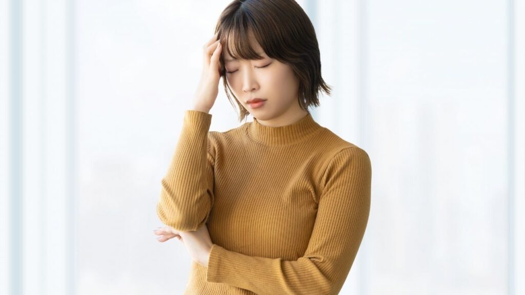 頭を抑える女性