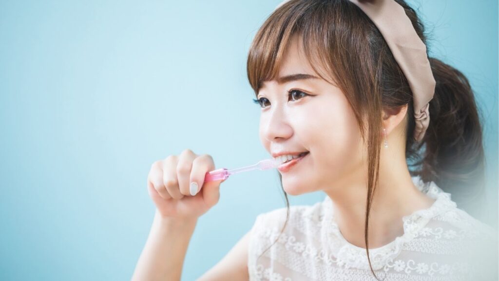 笑顔で歯磨きをする女性